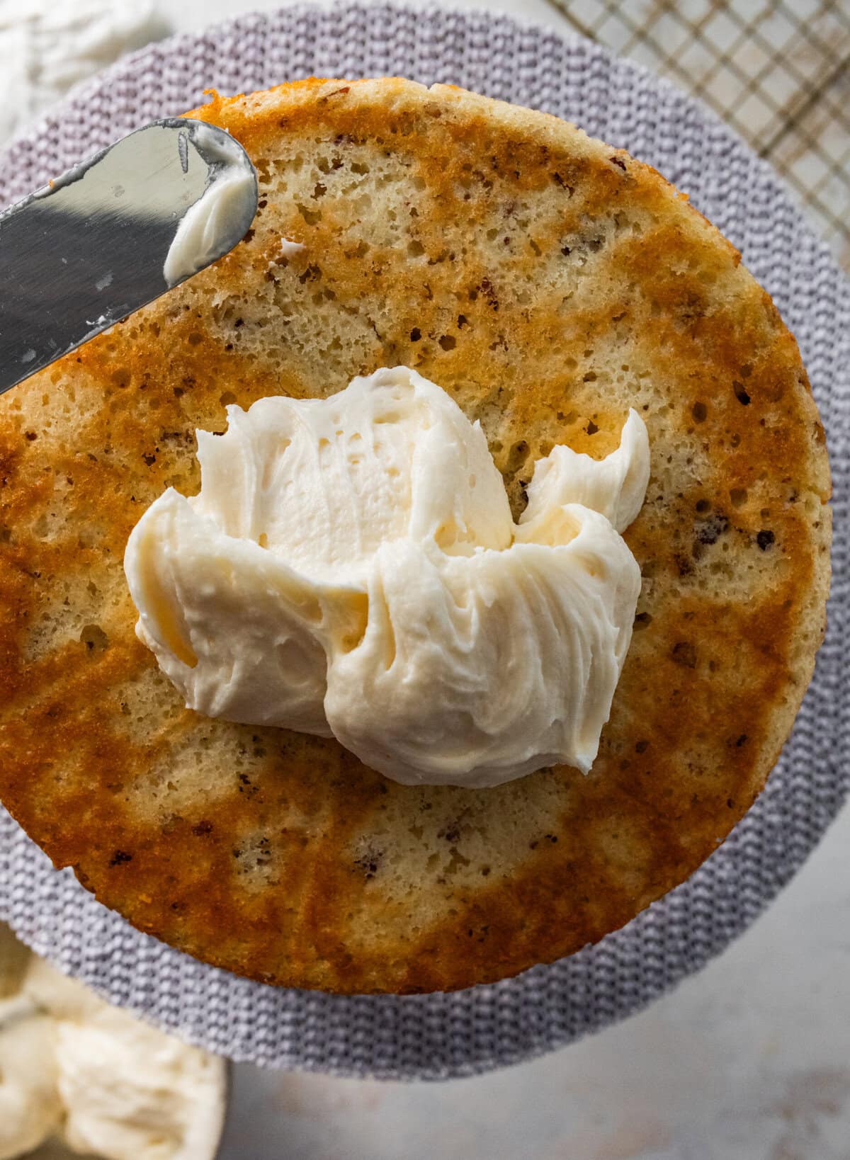 layering frosting in the middle of the Italian cream cake layers.