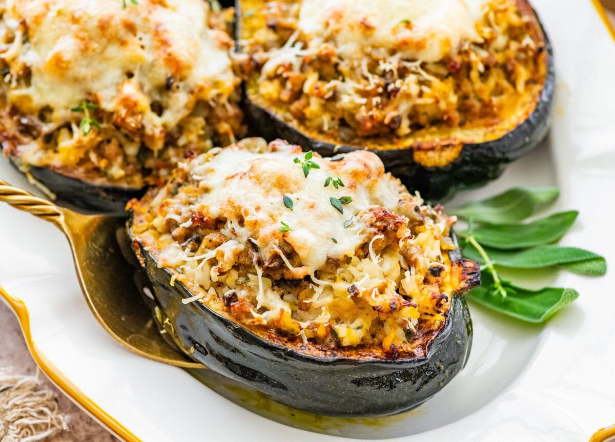 baked acorn squash on a plate with herbs on the side. 