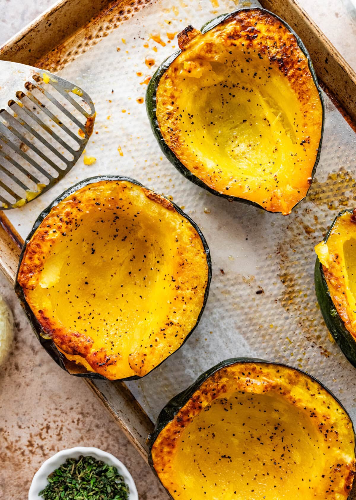Baked acorn squash on a cookie sheet.