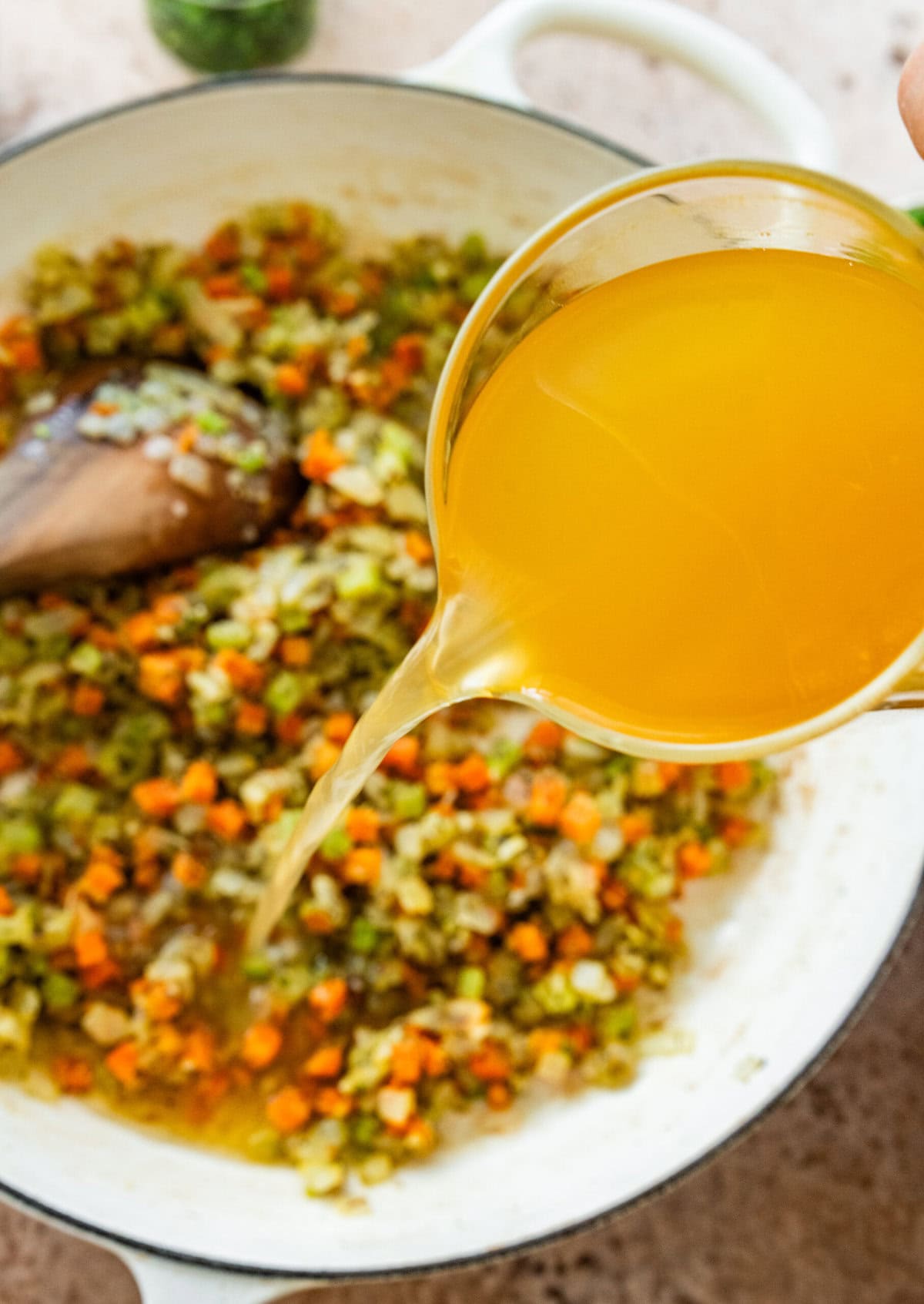 adding broth to the turkey shepards pie mixture in a pot.