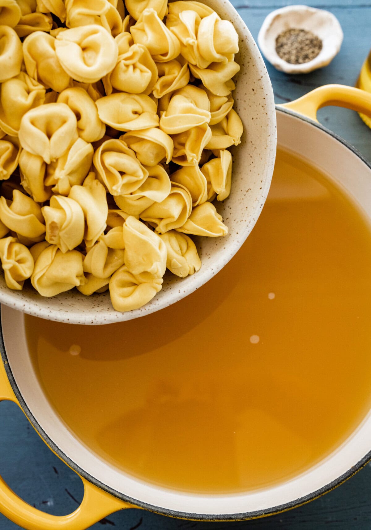 Adding the tortellini to the broth. 