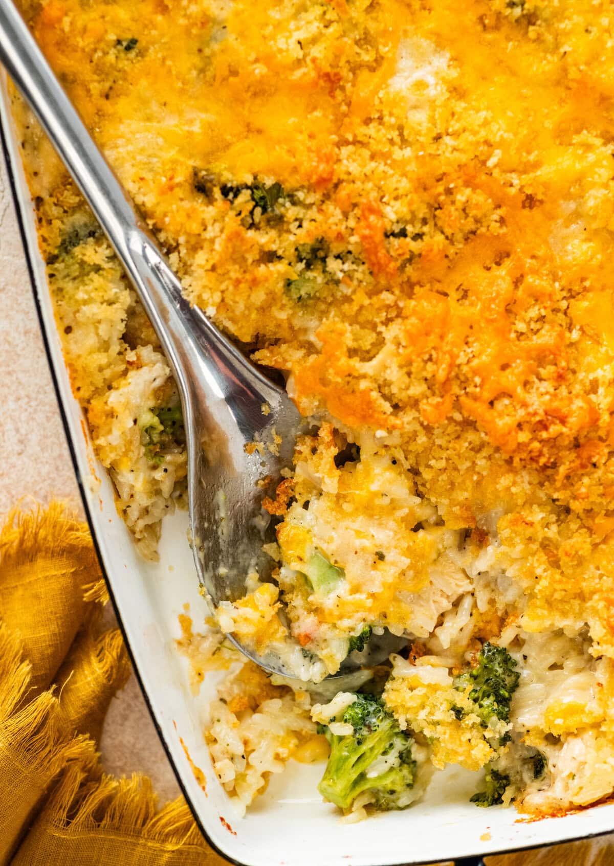 serving spoon with a portion of the chicken broccoli and rice casserole showing delicious layers.