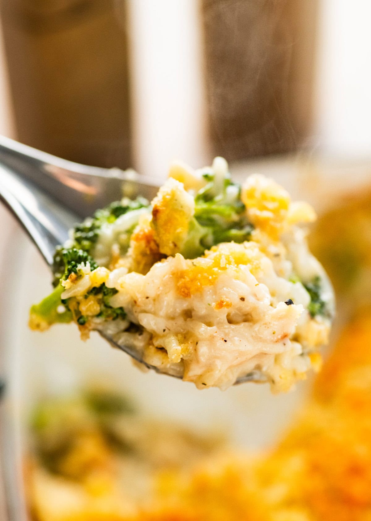 serving spoon with a portion of the chicken broccoli and rice casserole showing delicious layers.