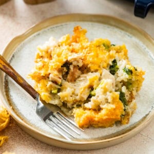 plate of chicken broccoli and rice casserole with a fork ready to eat.