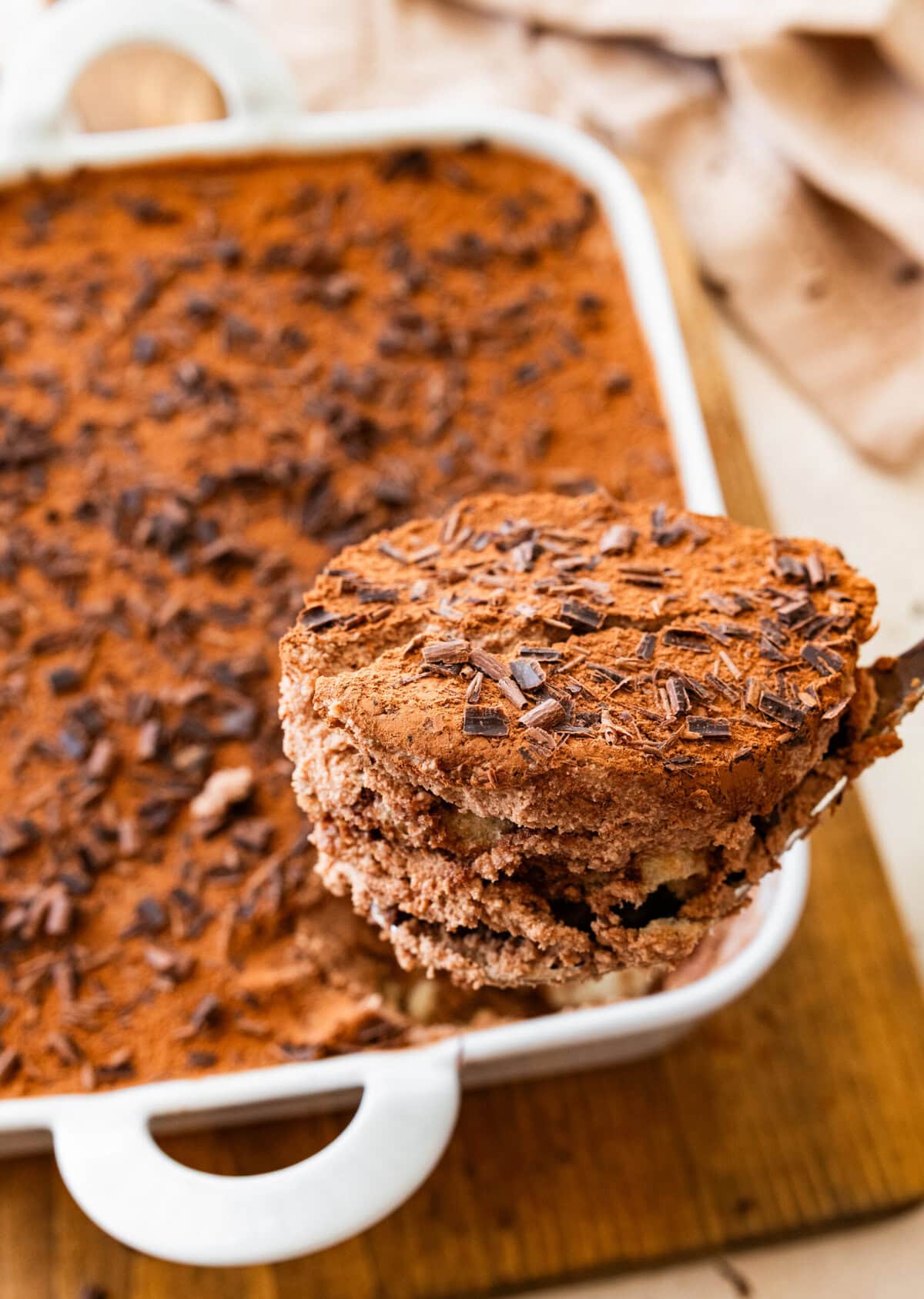 a serving spoon with layers of chocolate tiramisu ready to serve.