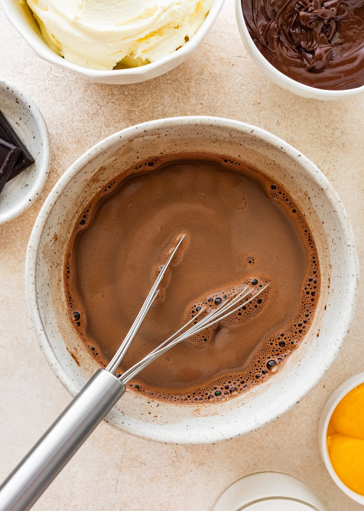 hot chocolate mixture in a bowl with a whisk.