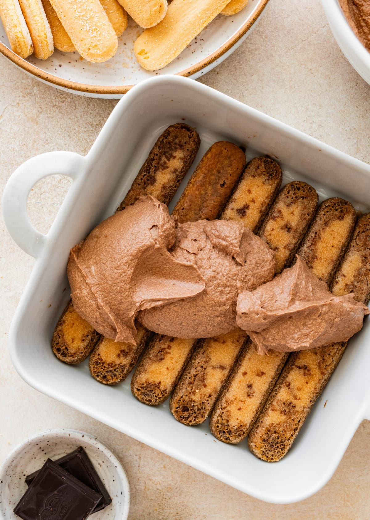 dipped ladyfinger cookies in a serving dish with layers of chocolate cream.
