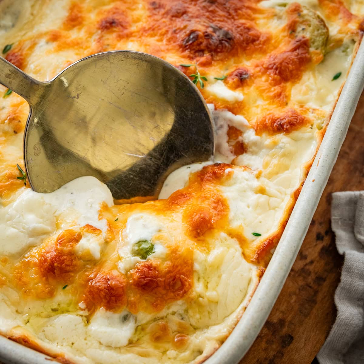 baked creamy brussels sprouts in baking dish with golden brown cheesy topping.