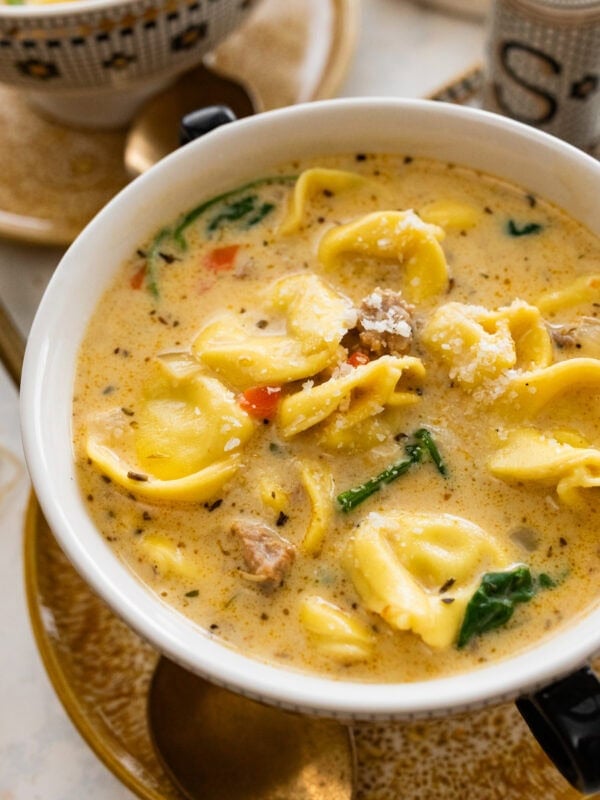 white bowl with creamy sausage tortellini ready to eat.
