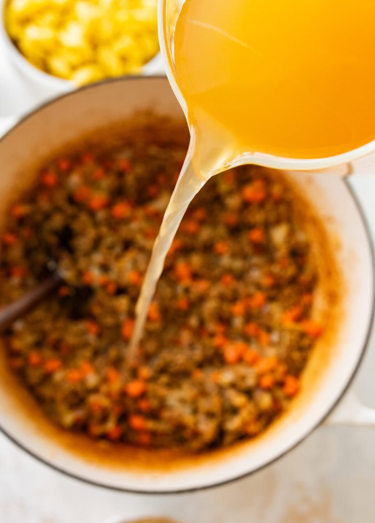 add broth to the pot and cook.