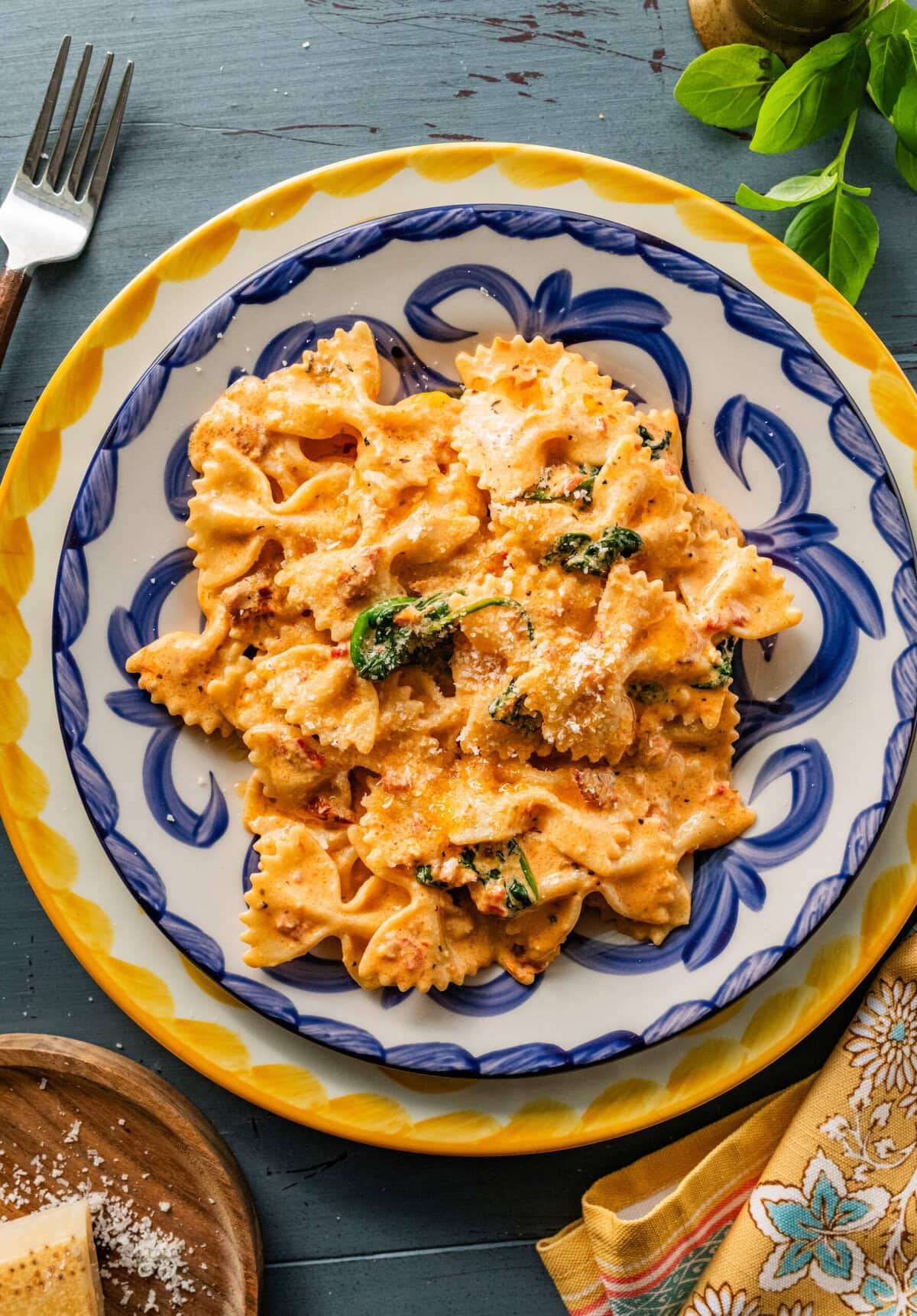 serving of pasta in a blue and white plate with fork in it.
