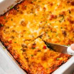 knife cutting a square of the breakfast casserole.