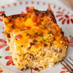 one piece of the hashbrown breakfast casserole on a plate with a fork by it.