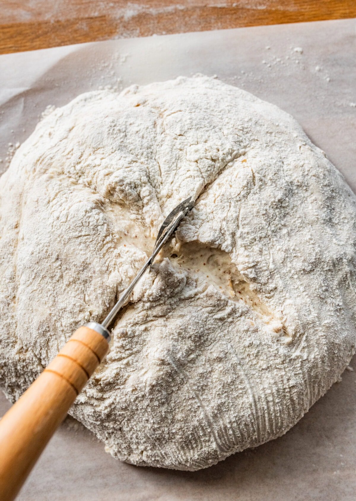 Using a knife to score the top of the bread boule. 