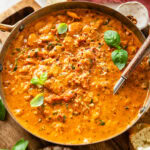 serving dish with creamy marry me butter beans with a serving spoon holding some to serve.
