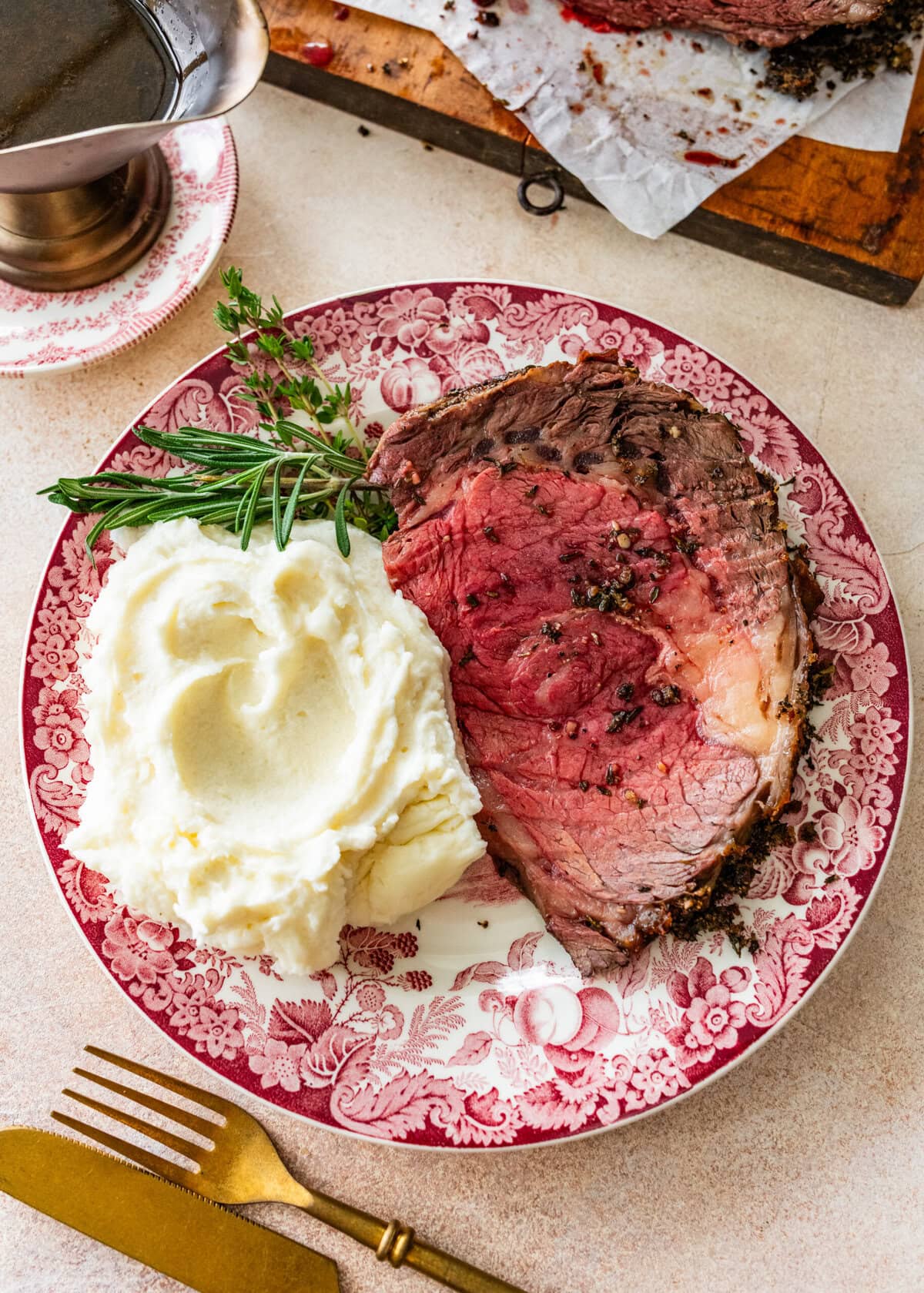 plate with a slice of prime rib roast meat and mashed potatoes.