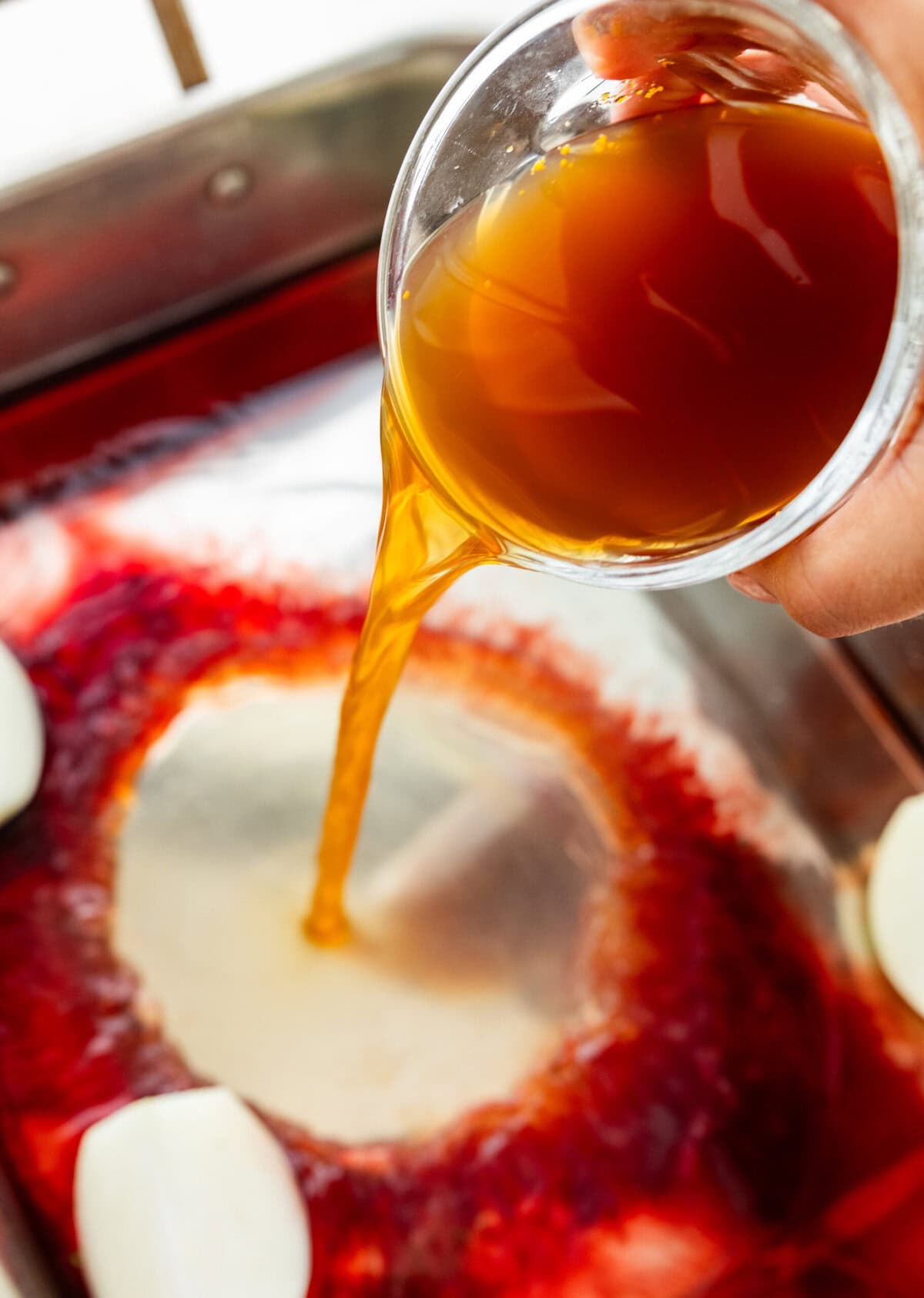 pouring liquid in bottom of roasting pan.