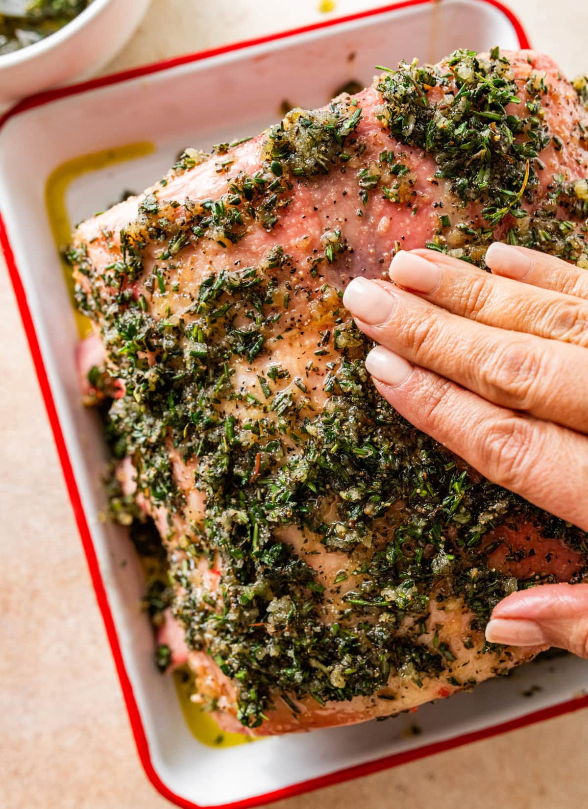 hand rubbing the herb rub on the standing prime rib roast.