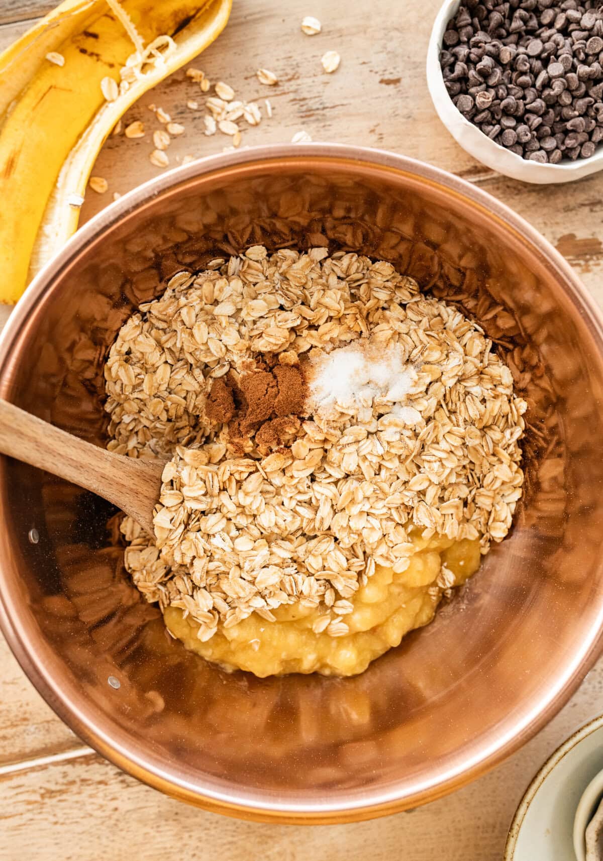 mashed banana, oats, salt and cinnamon in a wooden bowl.