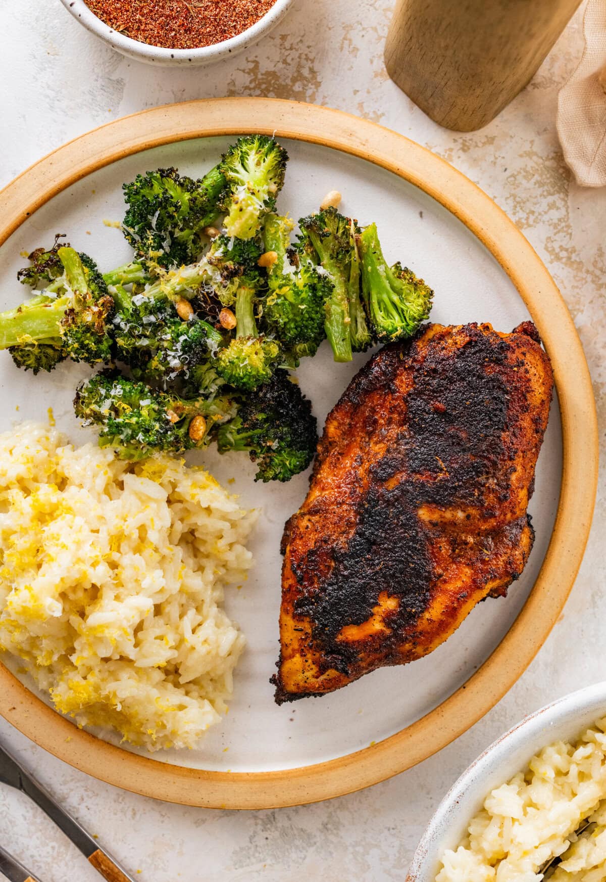 super juicy blackened chicken in a plate with lemon rice and broccoli.