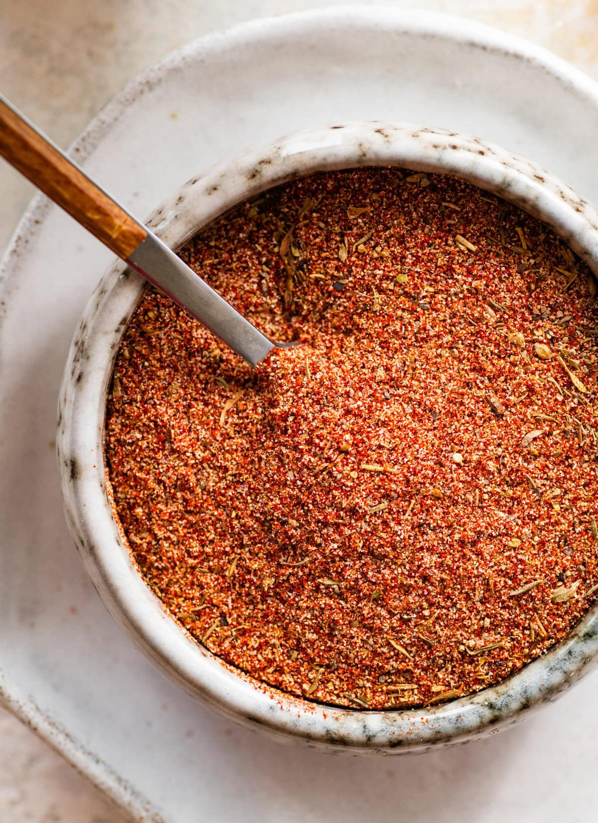 blackened seasoning in a white bowl with a spoon in it.