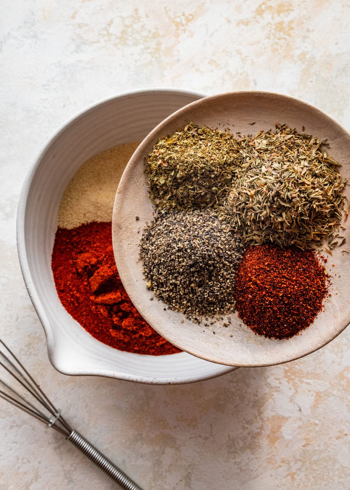 a plate with the rest of the blackened seasoning ingredients adding to the other bowl.