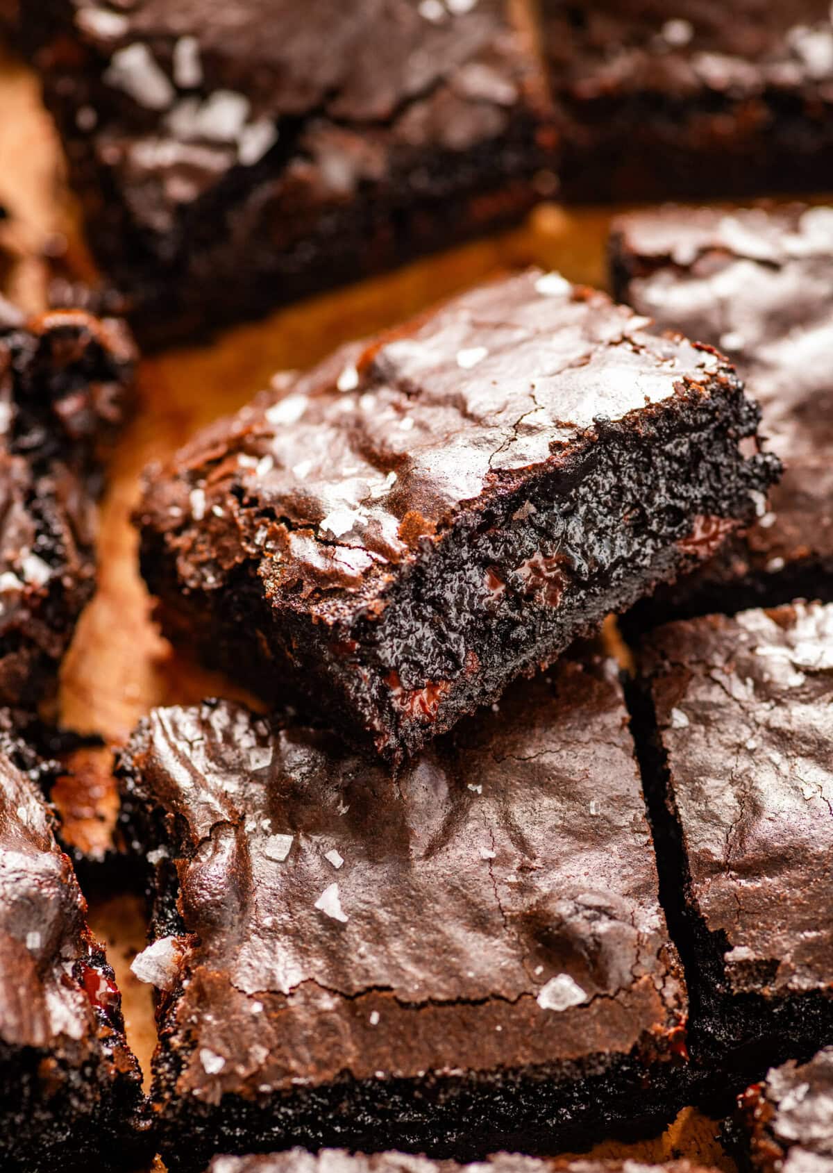 brown butter brownies cut into squares on parchments paper. sprinkle of flake salt on the top.