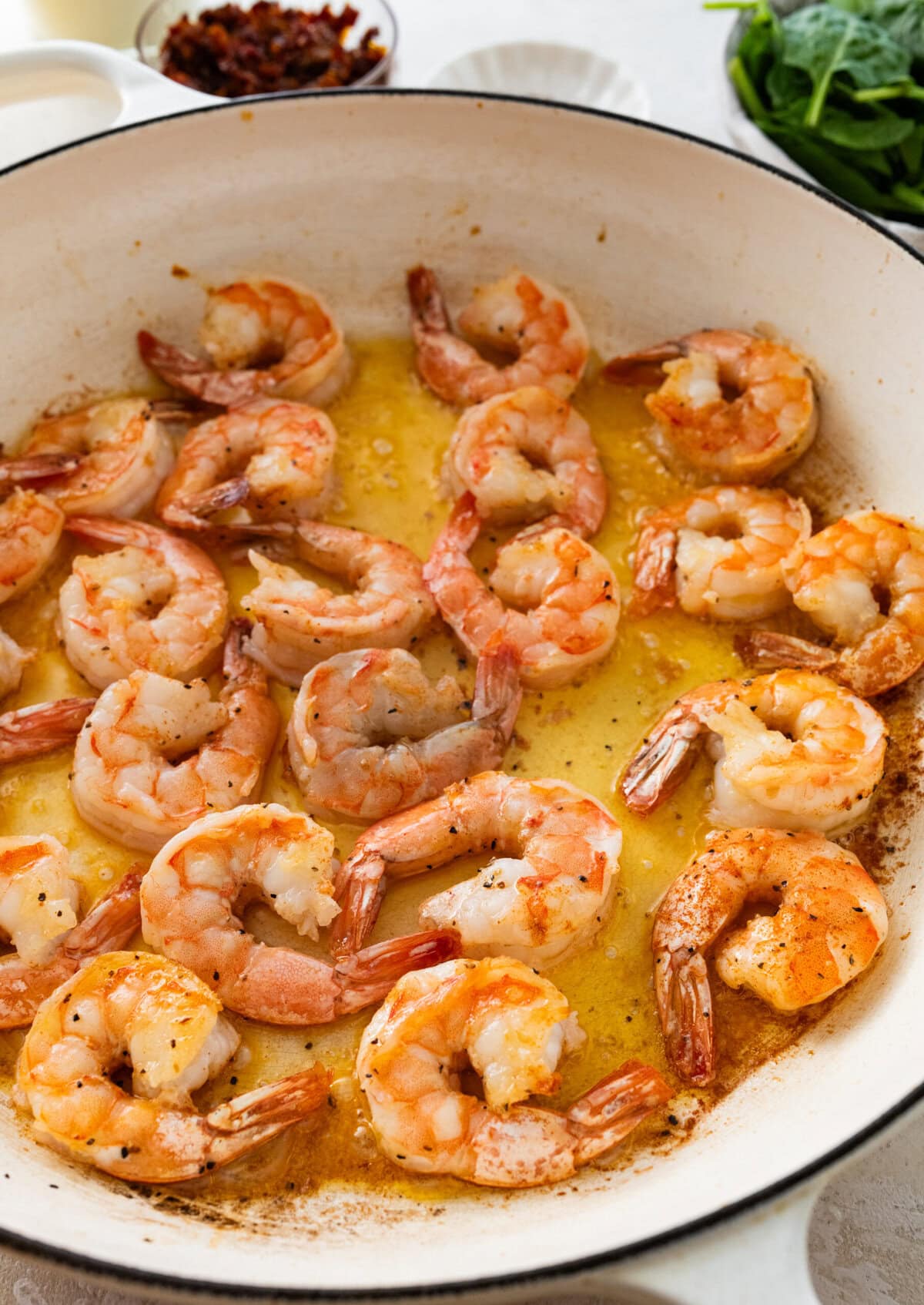 shrimp cooking in a pan with olive oil.