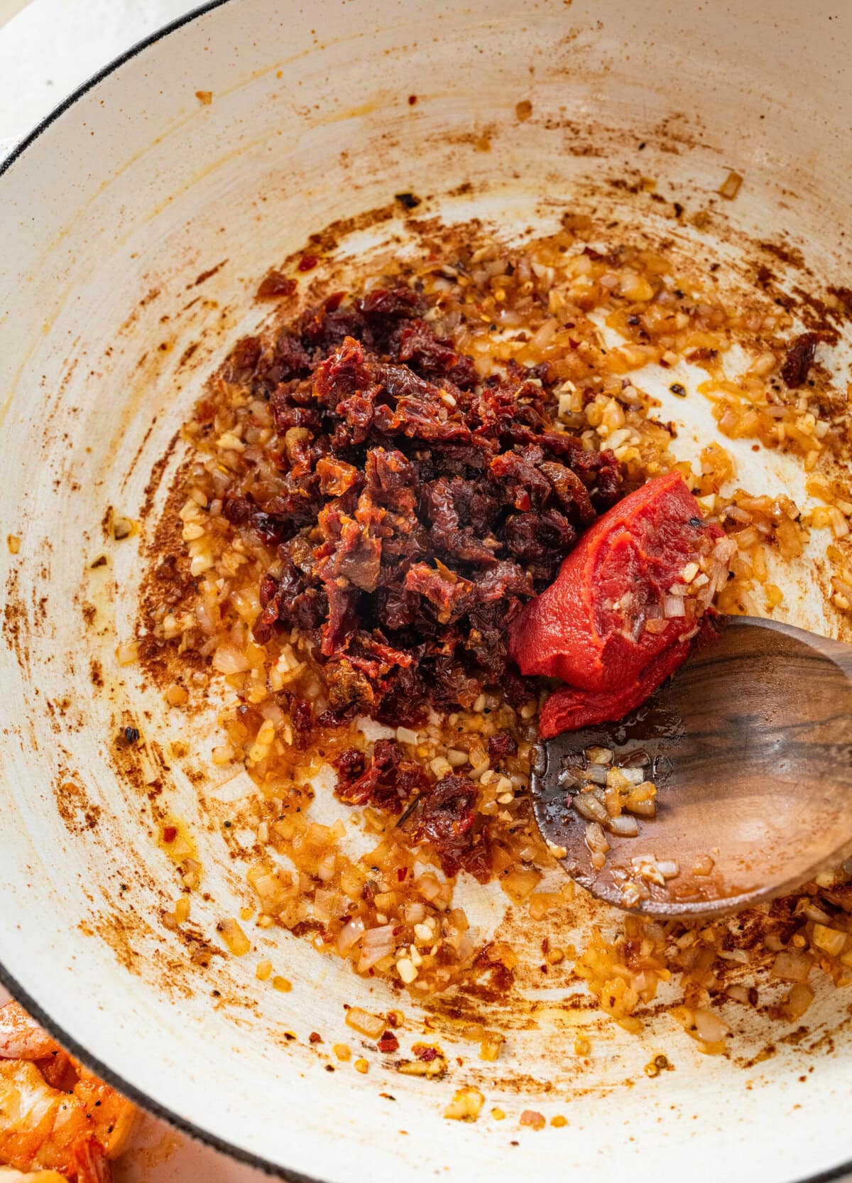 sun-dried tomatoes and tomato paste with garlic in a pan.