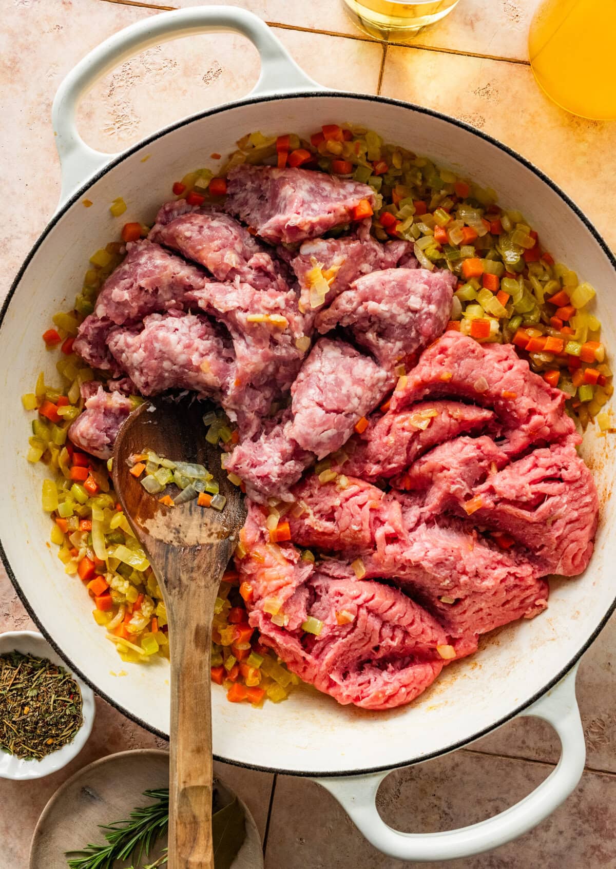 adding the ground meats to the pot with the cooked sofrito.