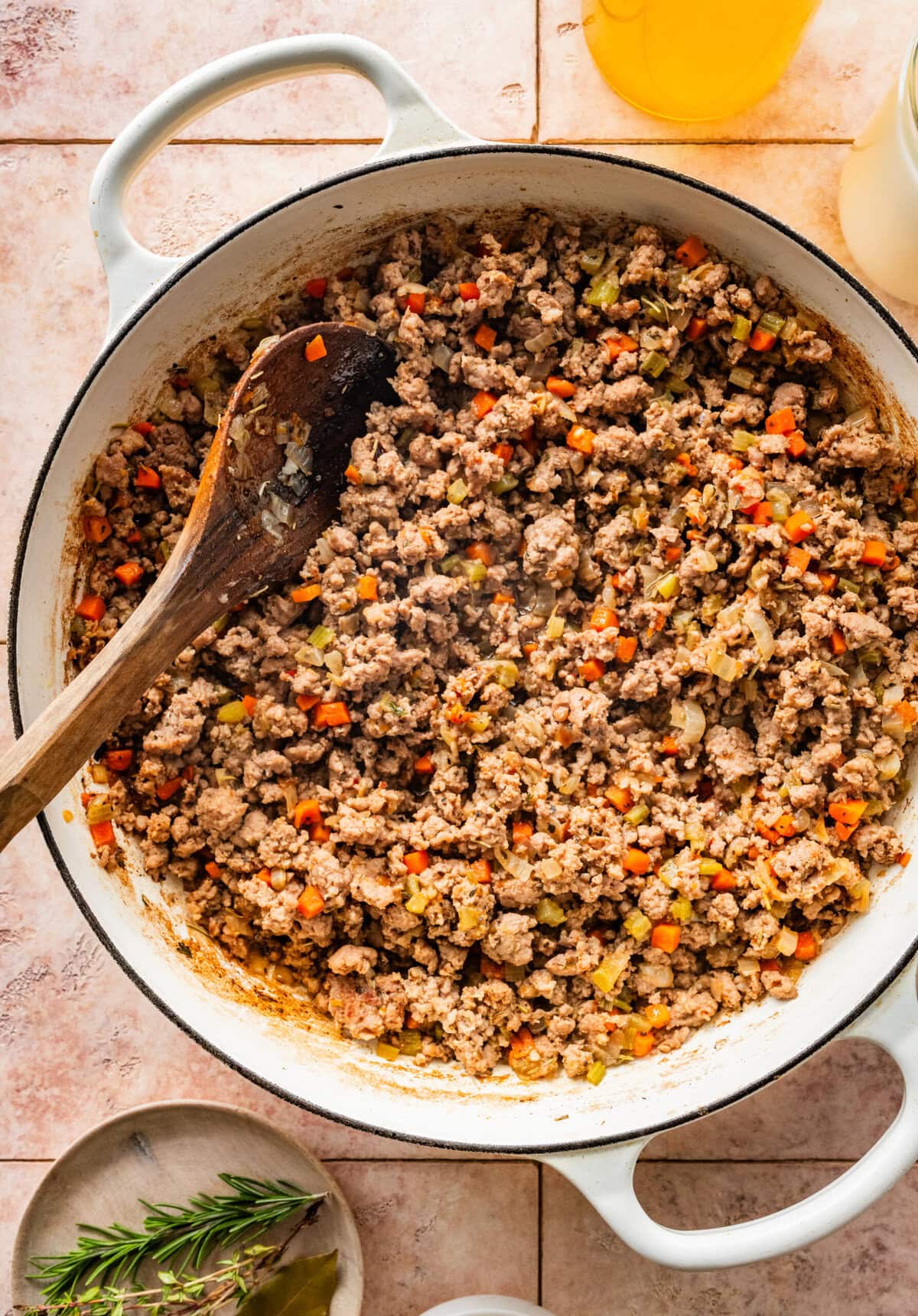 cooked meat and vegetables in pan with wooden spoon.