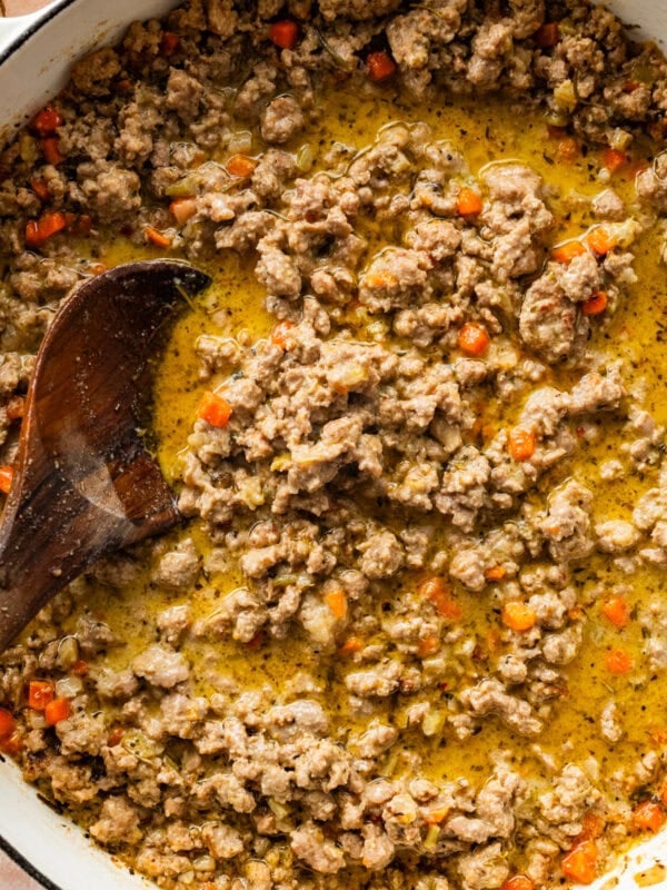 cooked white bolognese sauce in a large pot with a wooden spoon in it.