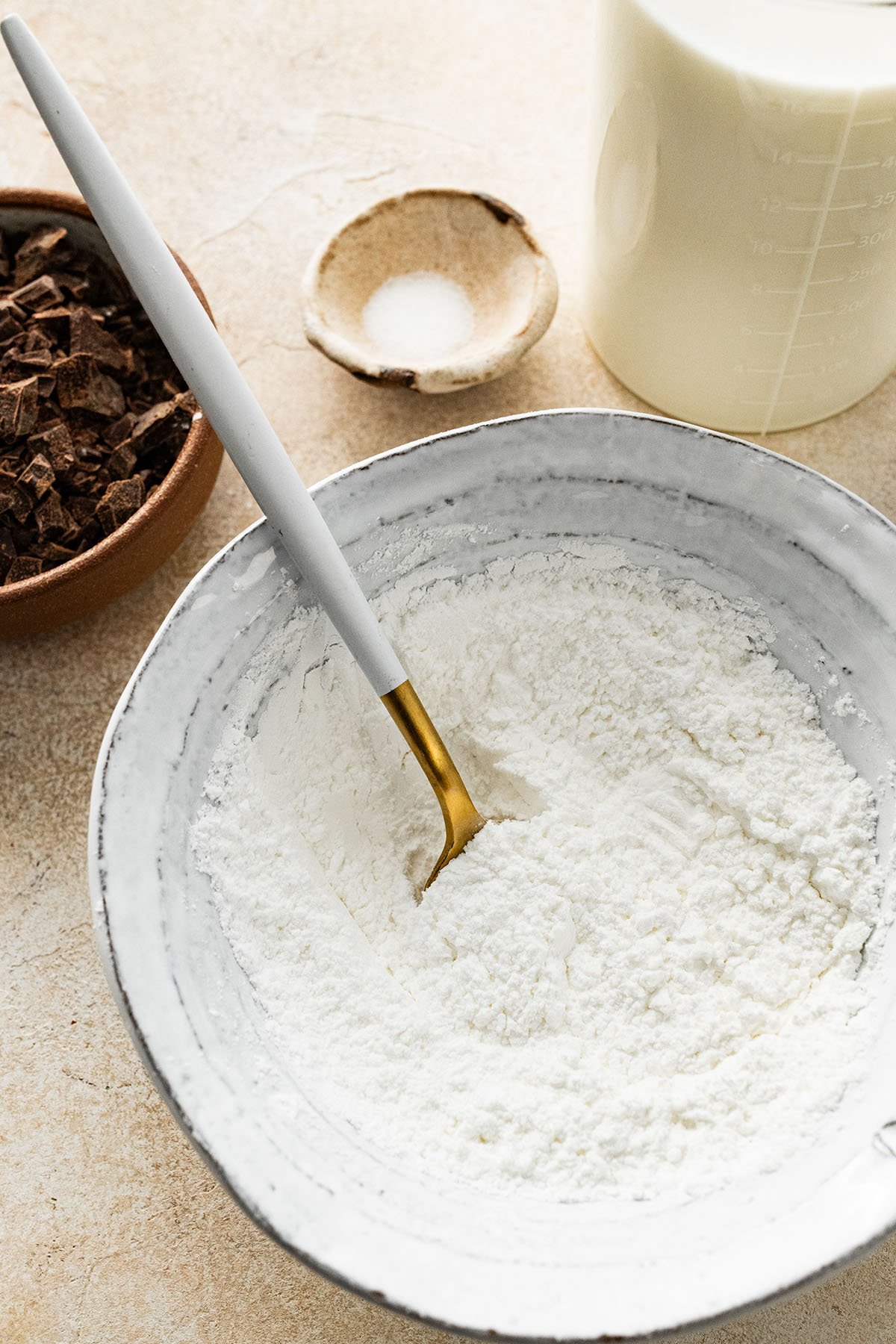 stirring cornstarch and powdered sugar in a bowl with a spoon.