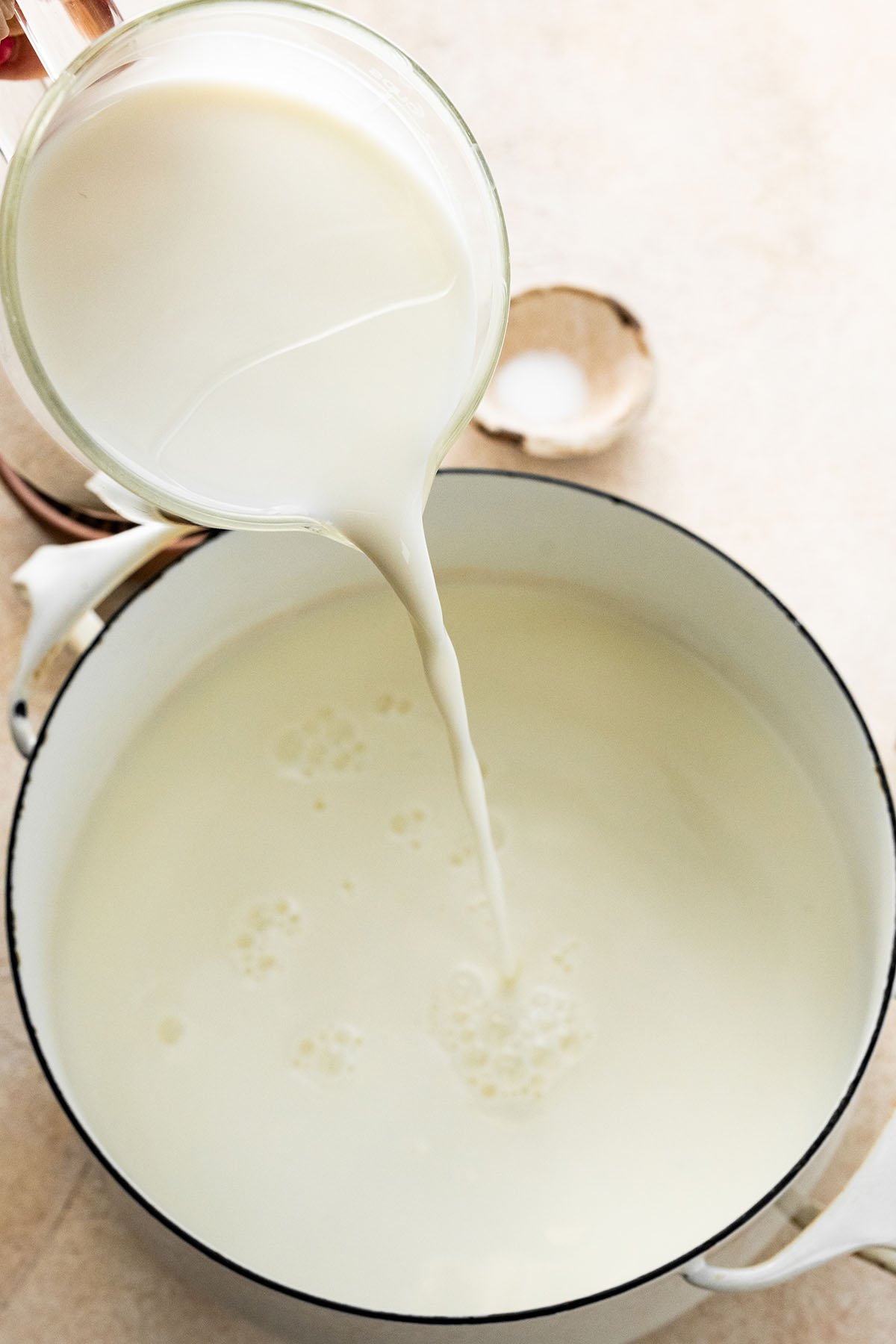 pouring milk into a Dutch oven.