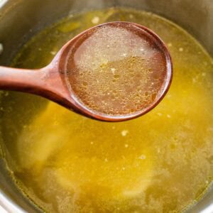 homemade broth in a ladle.