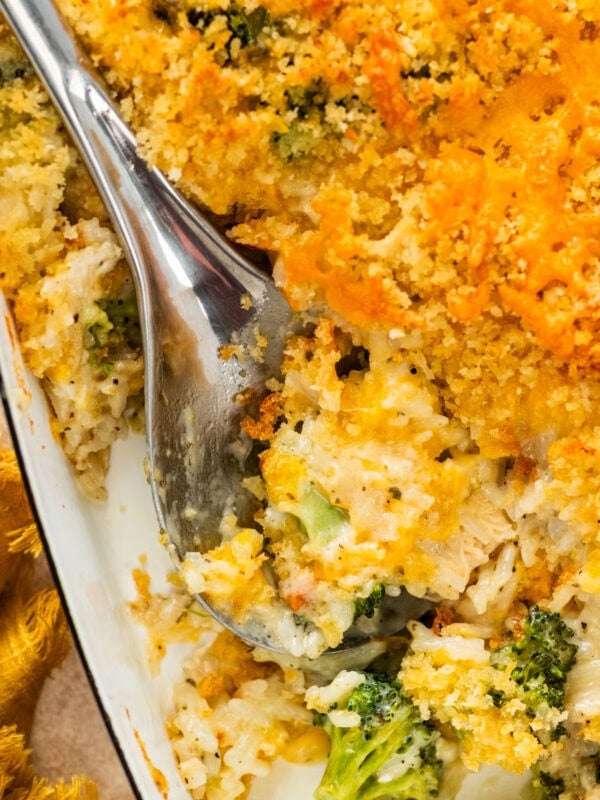 serving spoon with a portion of the chicken broccoli and rice casserole showing delicious layers.