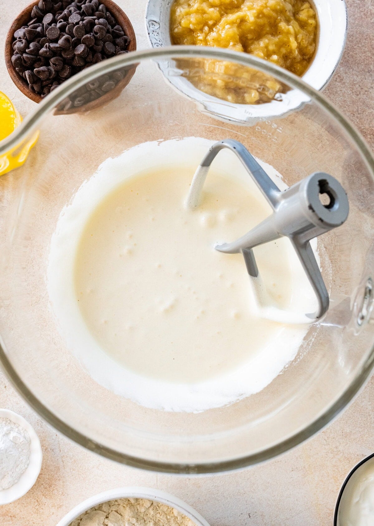 Eggs and sugar in a large bowl after beating completely, with other banana bread ingredients laid out.