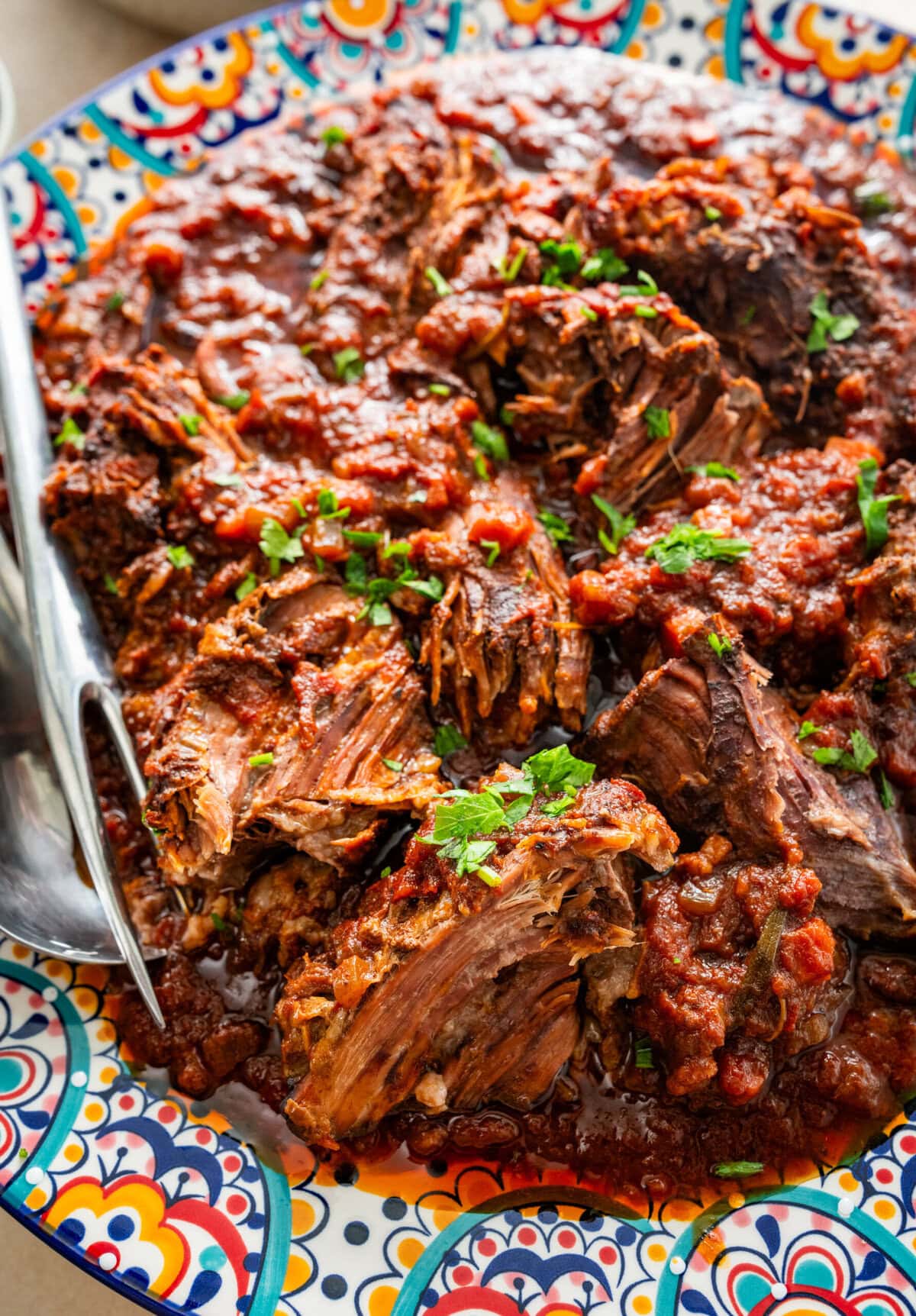 Italian pot roast with garnish on a serving plate.