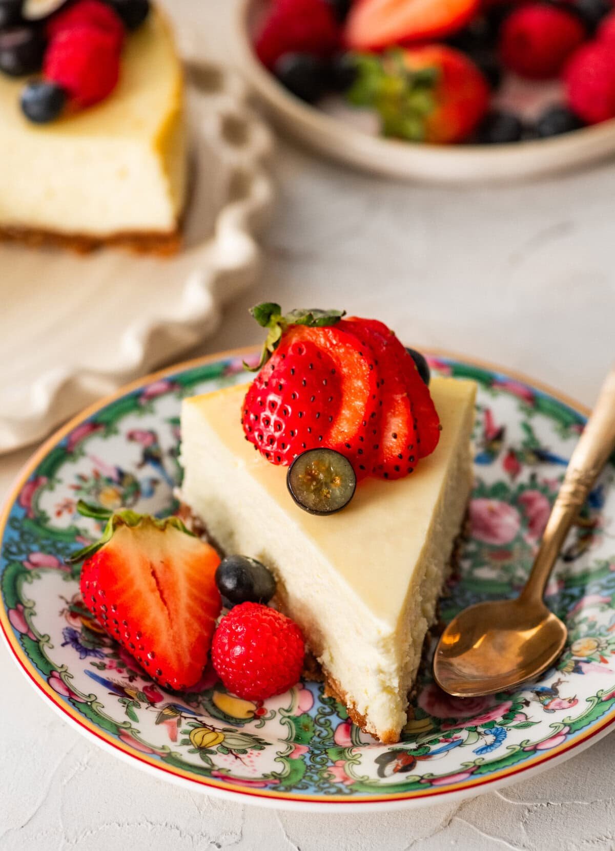 a slice of ricotta cheesecake topped and plated with berries.