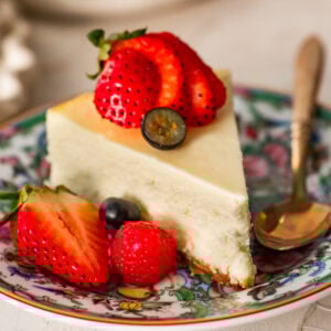 a slice of ricotta cheesecake topped and plated with berries.