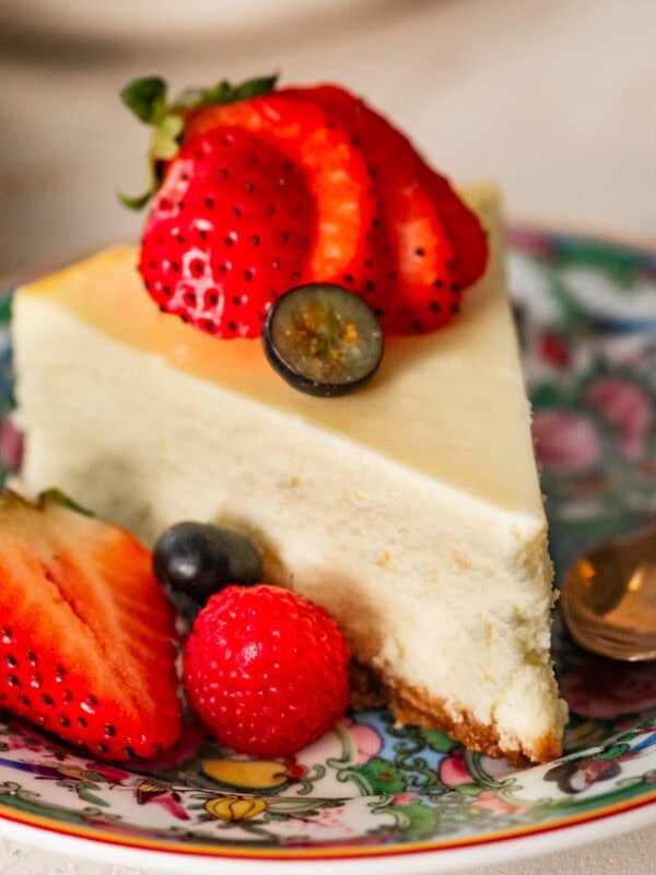 a slice of ricotta cheesecake topped and plated with berries.