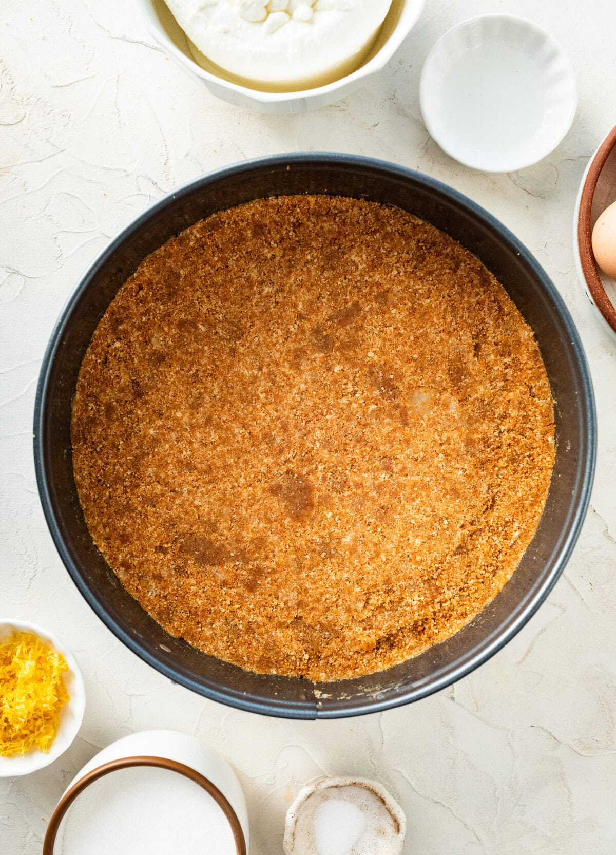 ricotta cheesecake crust mixture firmly pressed into the bottom of a springform pan.