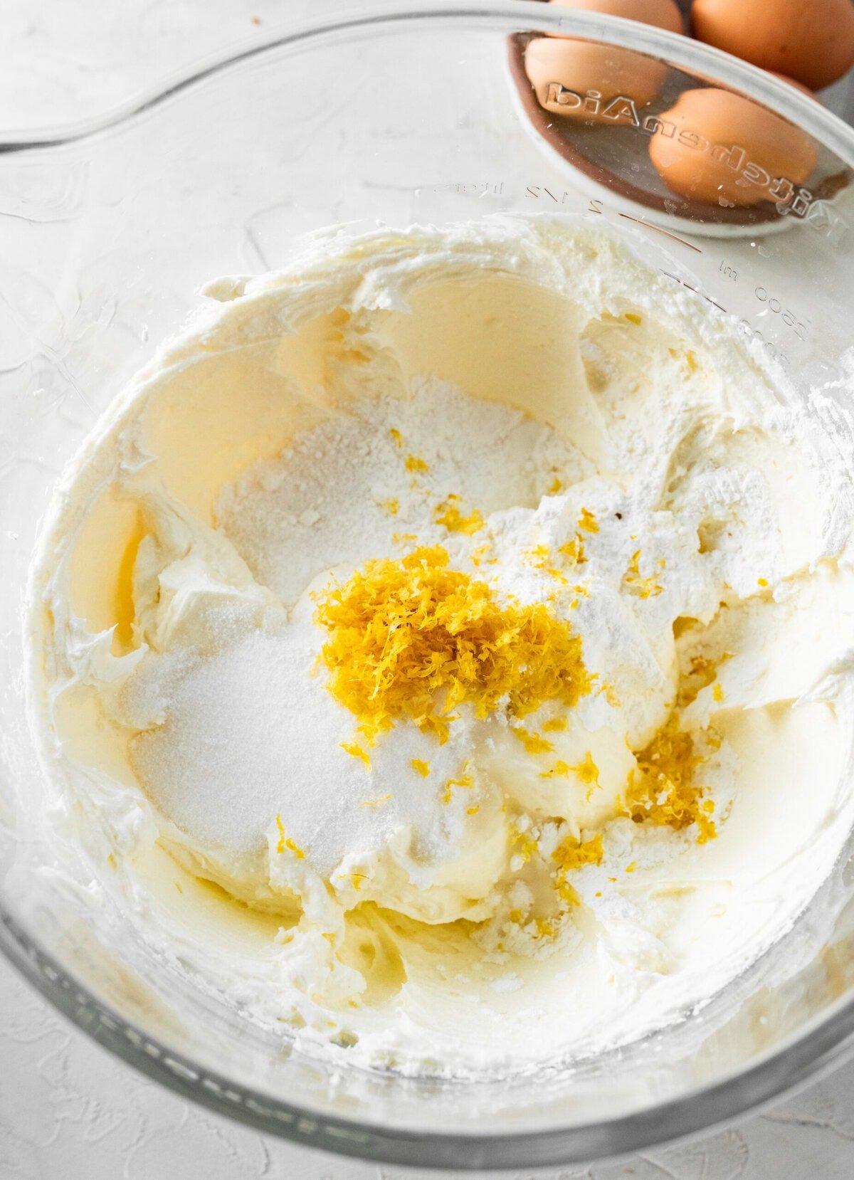 all of the ingredients, minus egg, to make the ricotta cheesecake filling in a bowl before mixing.