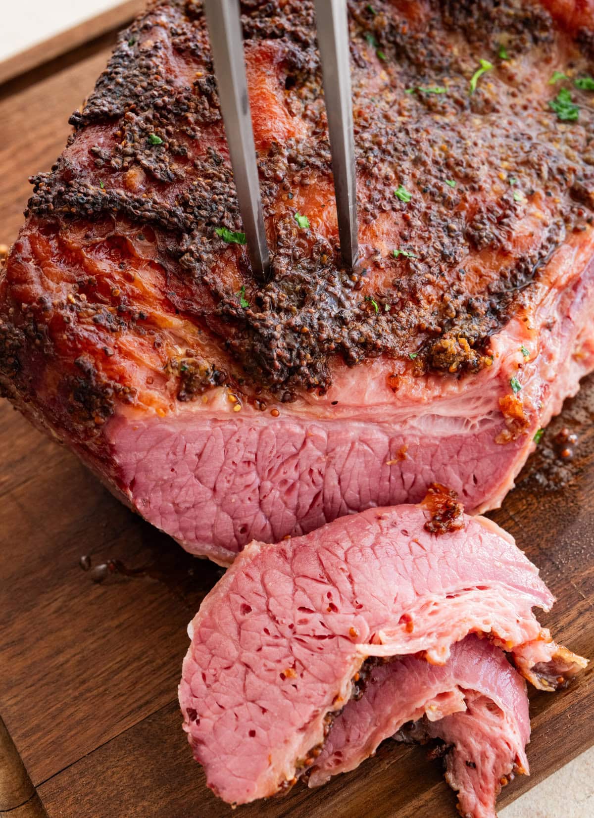 A slice of corned beef cut off, next to the rest.