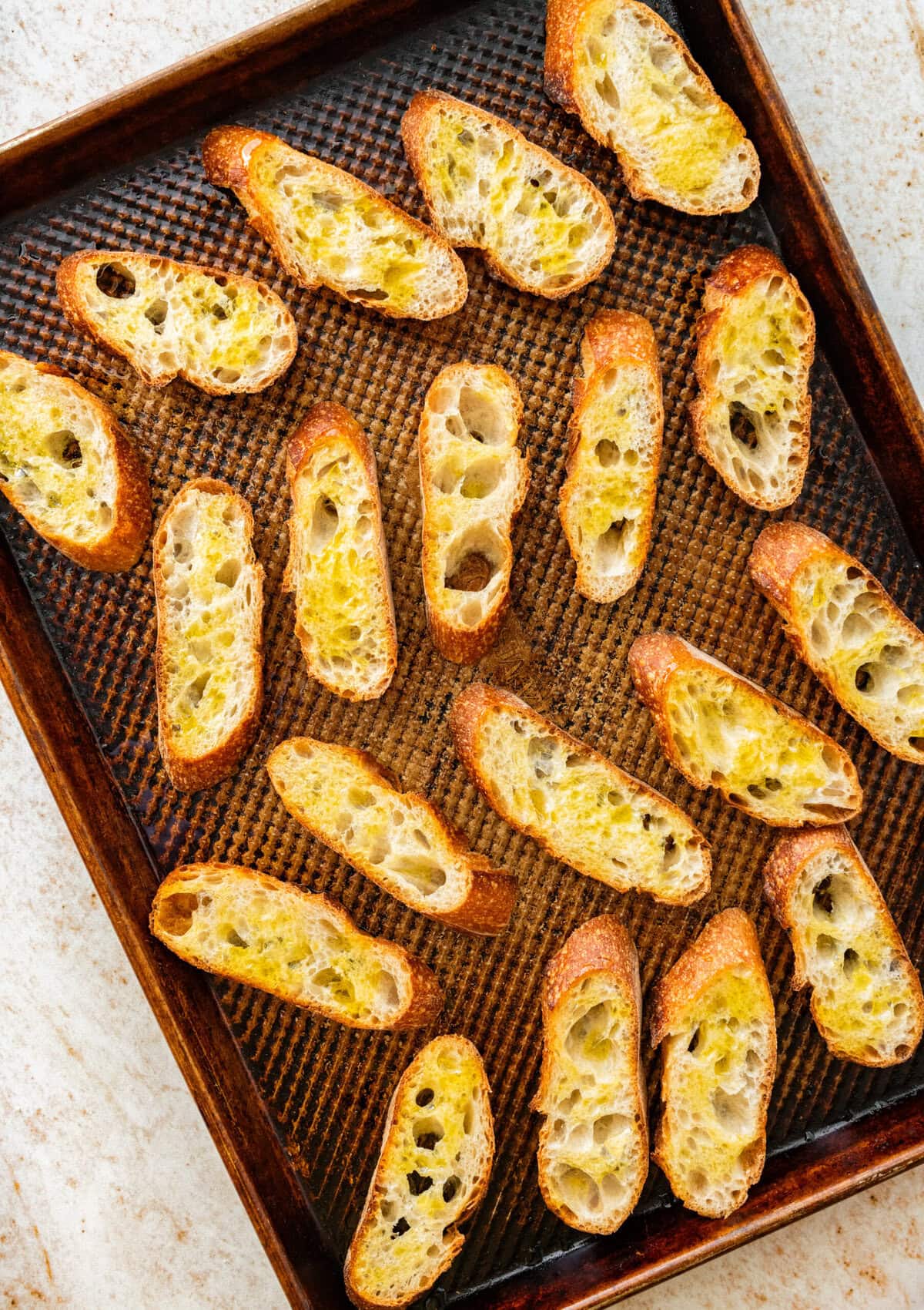 Bread slices on a baking sheet.