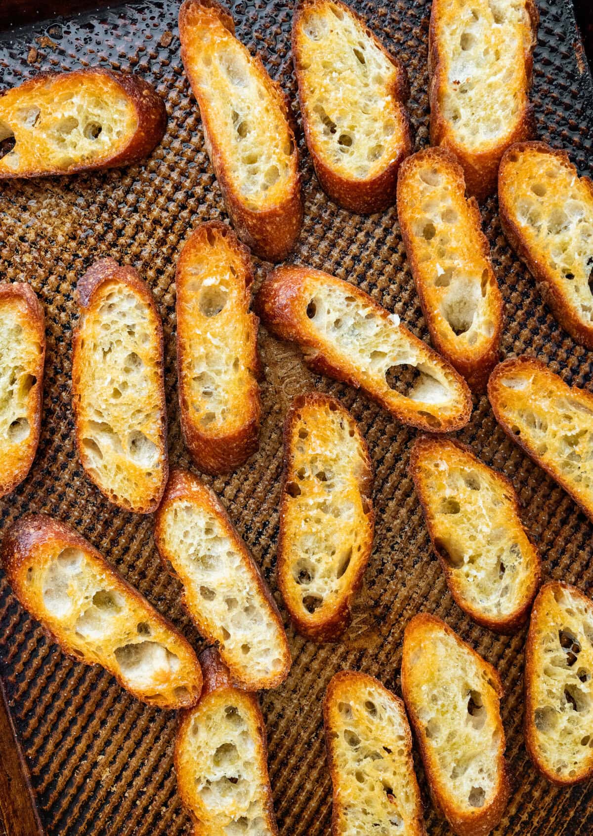 Bread slices on a baking sheet after removing from oven.