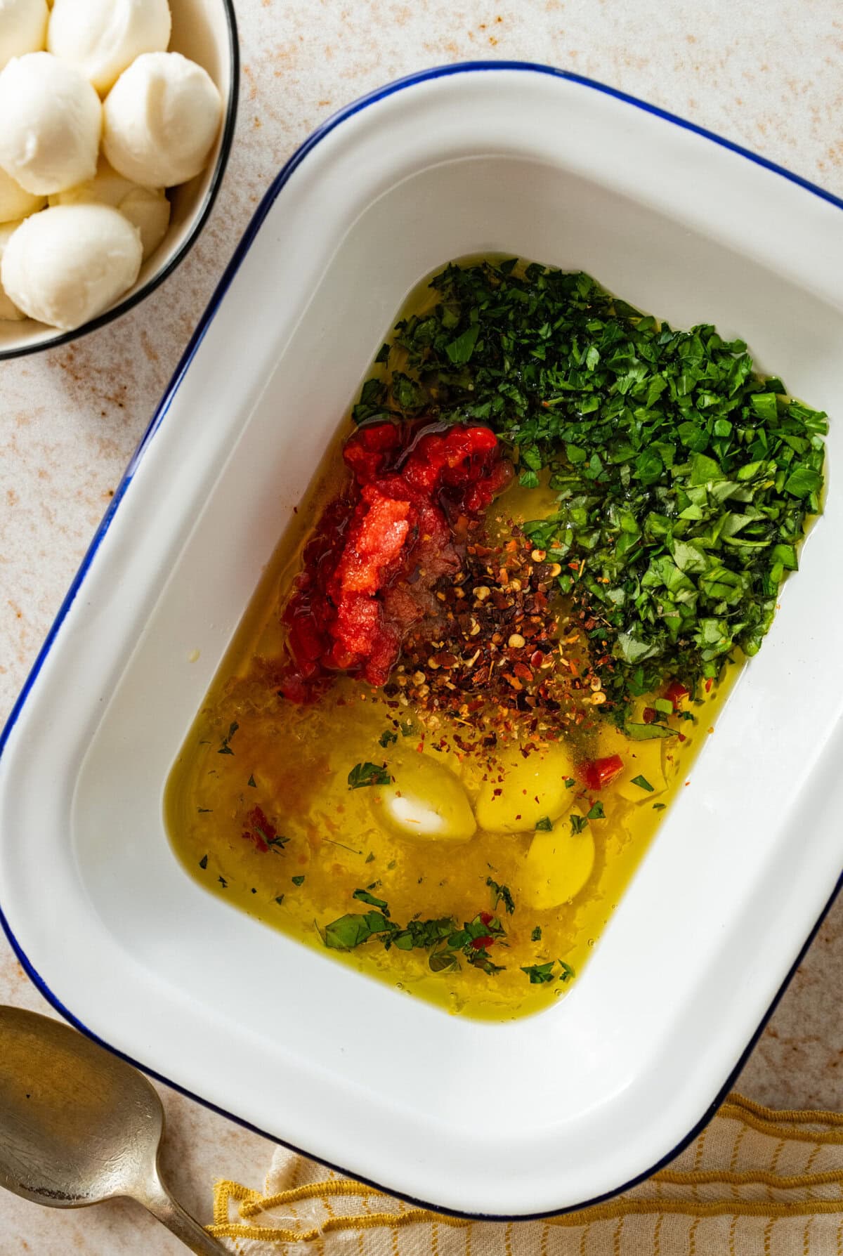 Olive oil combined in a dish with the marinade ingredients.