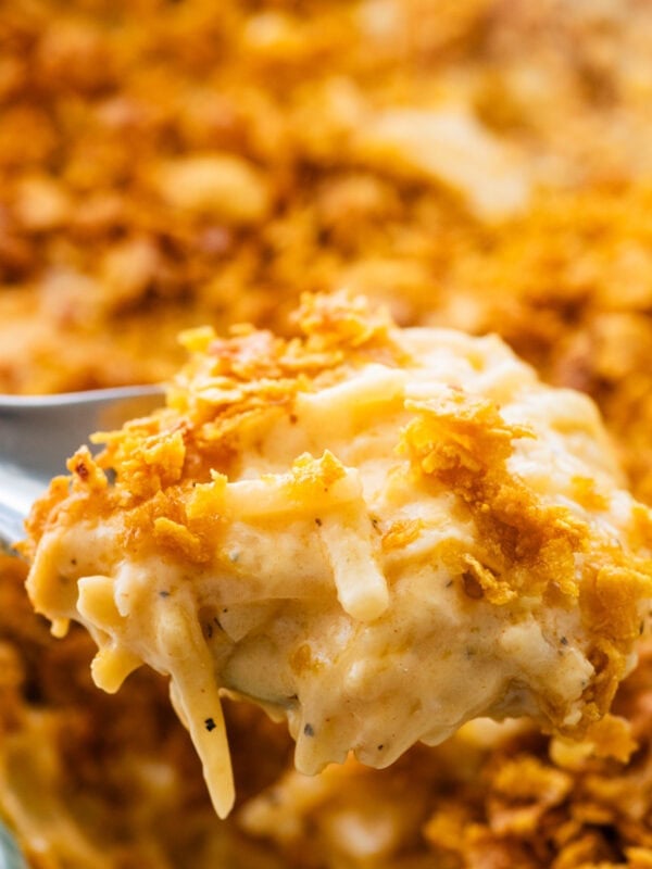 A fork holding up one bite of party potatoes.