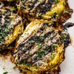 Roasted cabbage steaks drizzled with balsamic glaze, served on a plate.