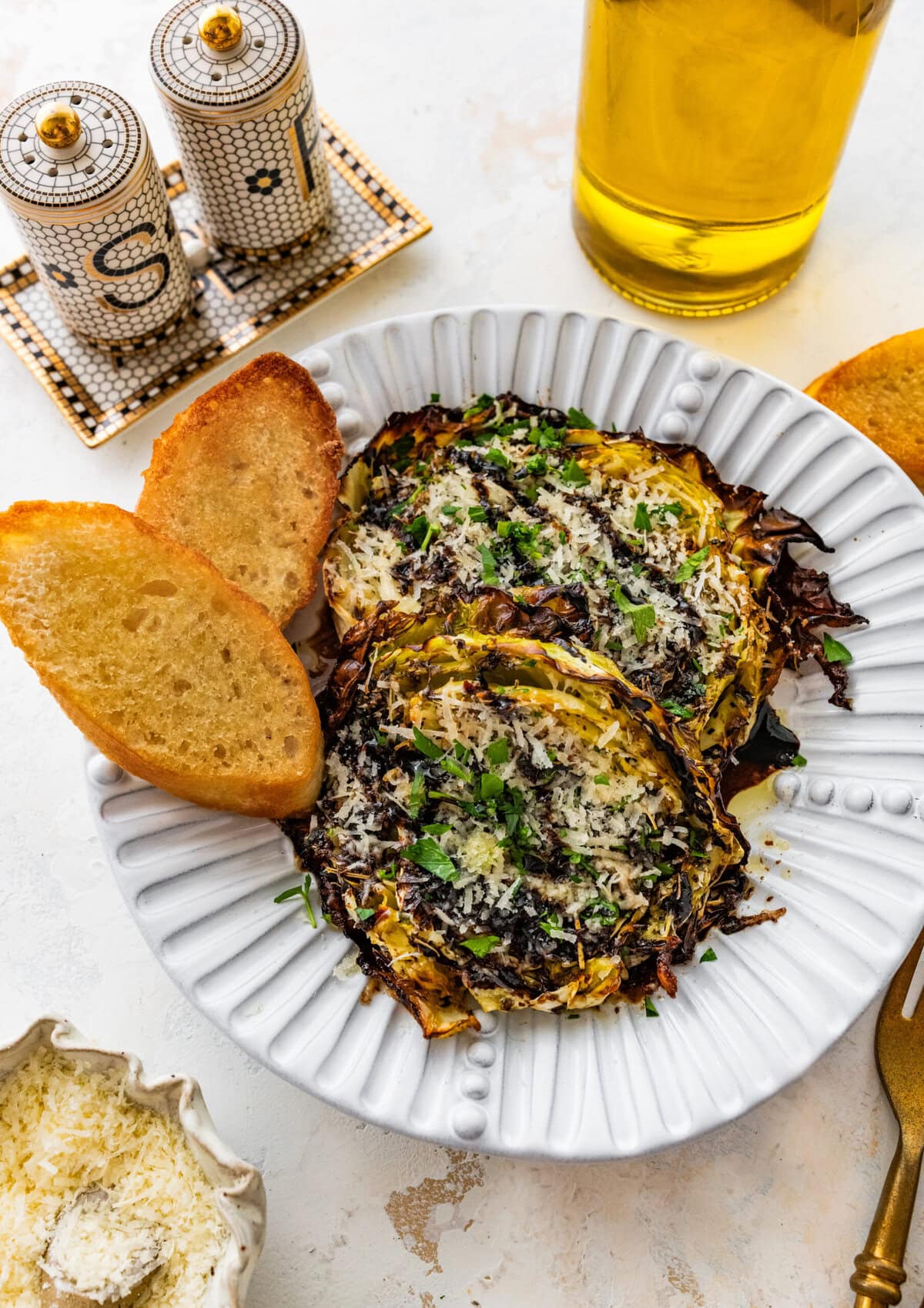 Roasted cabbage steaks drizzled with balsamic glaze, served on a plate with bread.